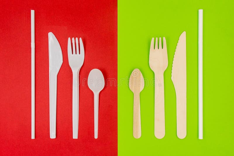 Plastiktischbesteck auf rotem Hintergrund- und ecofreundlichem Wegwerftischbesteck auf grünem Hintergrund lizenzfreies stockfoto