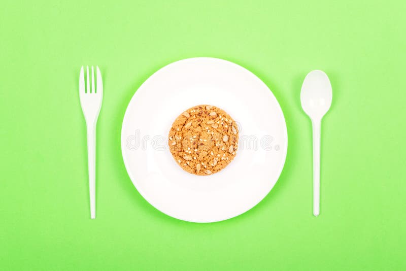 Plat blanc avec la cuillère, la fourchette et la farine d'avoine entière de biscuits de grain Régime Ketogenic, perte de poids, j photos stock Plat blanc avec la cuillère, la fourchette et la farine d'avoine entière de biscuits de grain Régime Ketogenic, perte de poids, j photos stock