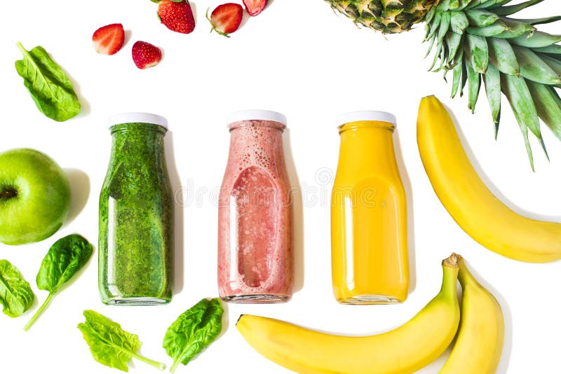 Plat-configuration des smoothies colorés dans des bouteilles avec des fruits frais et des baies d'isolement sur le fond blanc photographie stock Plat-configuration des smoothies colorés dans des bouteilles avec des fruits frais et des baies d'isolement sur le fond blanc photographie stock