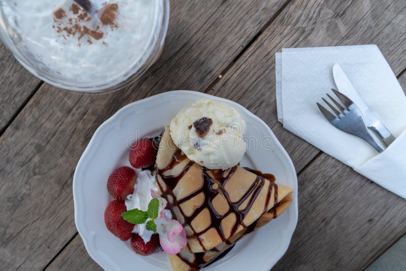 Plat de dessert de crêpe avec la fraise, la banane, et la crème glacée sur la table en bois photographie stock libre de droits Plat de dessert de crêpe avec la fraise, la banane, et la crème glacée sur la table en bois photographie stock libre de droits