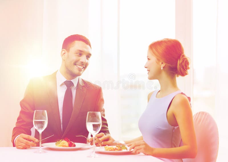 Plat principal de sourire de consommation de couples au restaurant image stock Plat principal de sourire de consommation de couples au restaurant image stock