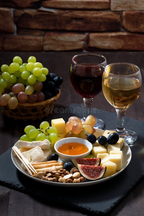 Plate with Deli Snacks and Wine on a Dark Background, Vertical Stock