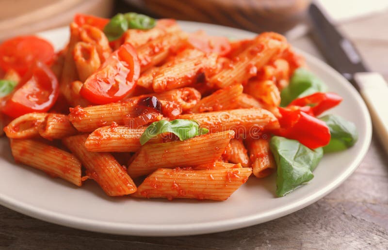 Plate with Delicious Penne Pasta and Garnish on Table, Closeup Stock ...