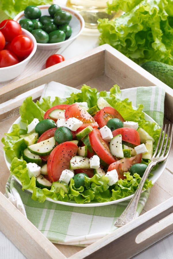 Plate of green salad with vegetables and feta, top view