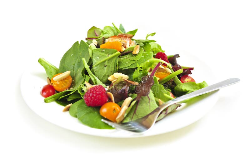 Plate of green salad on white background royalty free stock images