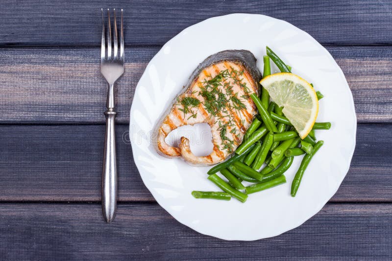 Plate of Grill Salmon Fish with Salad and Fork Top View Stock Image
