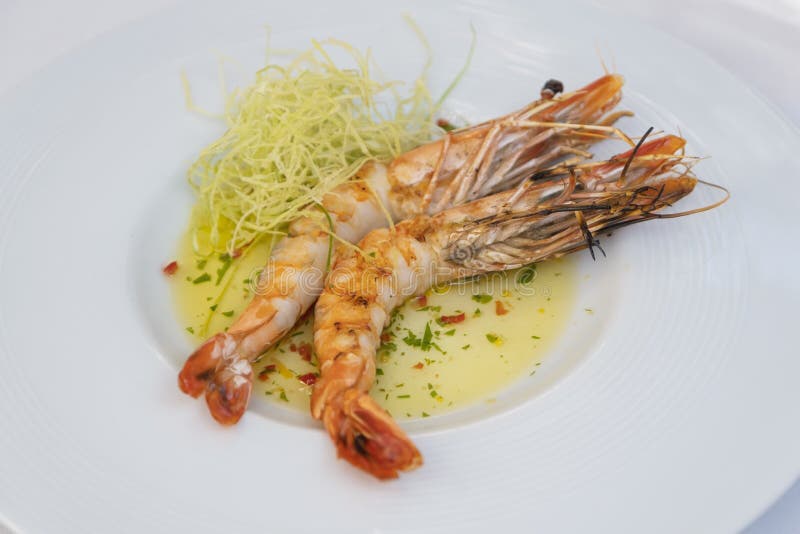 Plate of Grilled Prawns with Sauce and Vegetable Sides Stock Photo