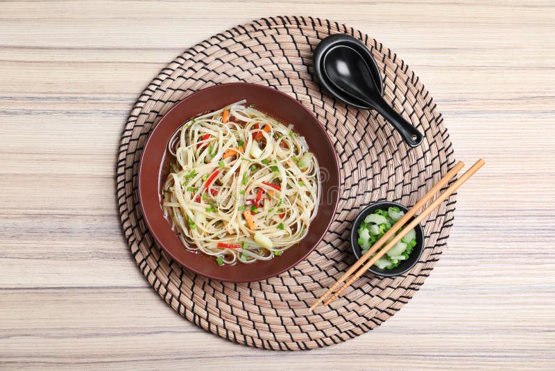 Plate Of Noodles, Broth And Vegetables Served With Chopsticks On Table