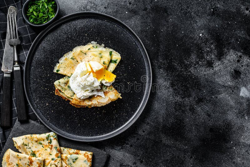 Plate of Pancake Stuffed with Spinach and Eggs. Black Background. Top