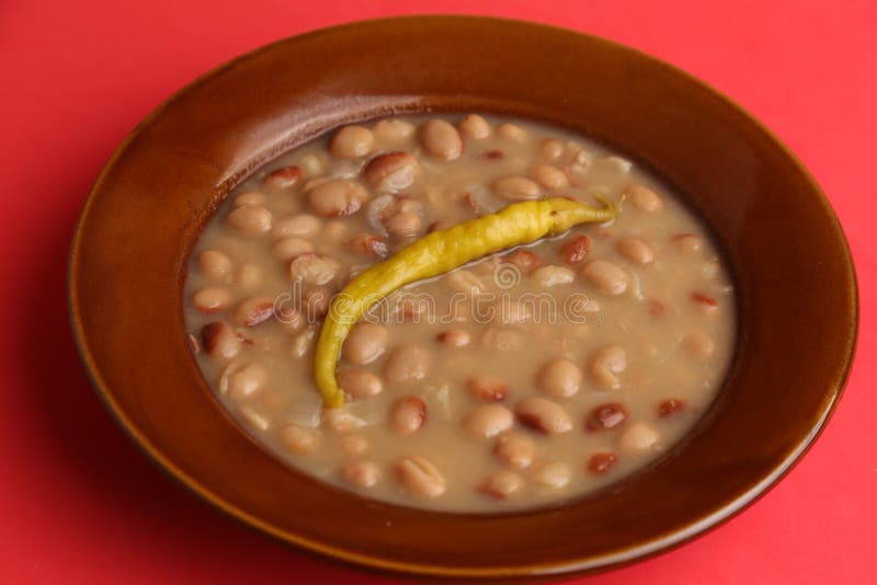 Plate of Red Beans with Chili Pepper on Red Background Stock Photo