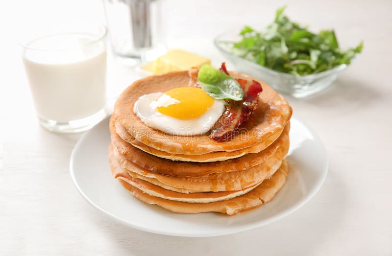 Plate with Tasty Pancakes, Fried Egg and Bacon on Wooden Table Stock