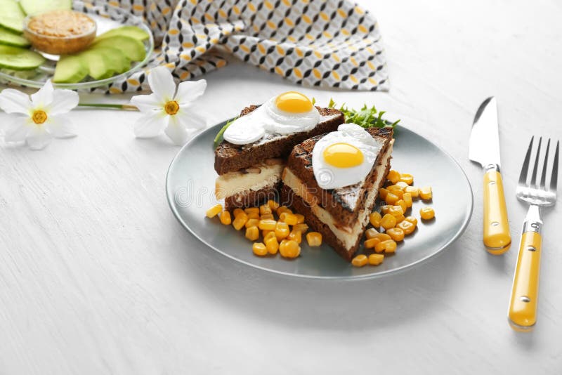 Plate with Toasted Bread, Fried Eggs and Corn Kernels on Table Stock