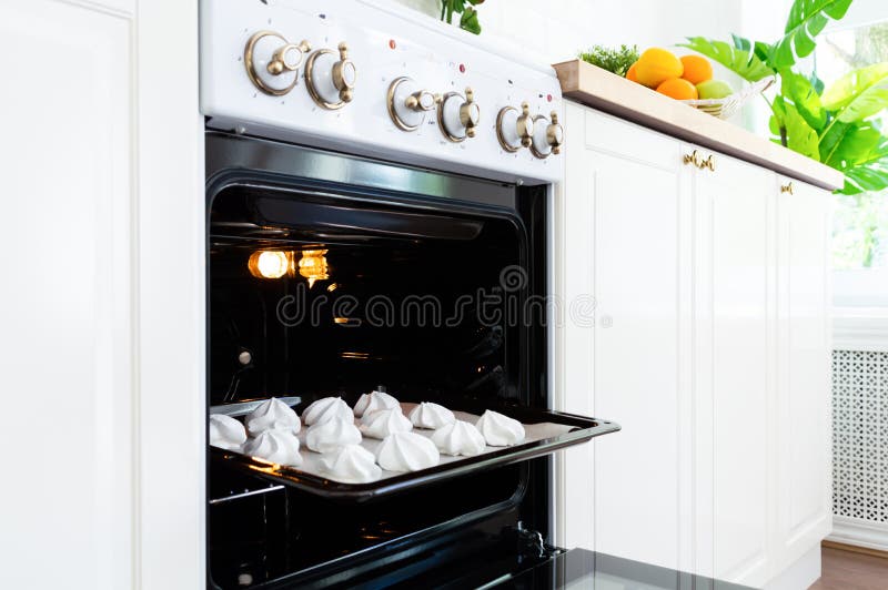 Plateau de cuisson avec les meringues douces dans le four sur la cuisine photographie stock libre de droits Plateau de cuisson avec les meringues douces dans le four sur la cuisine photographie stock libre de droits