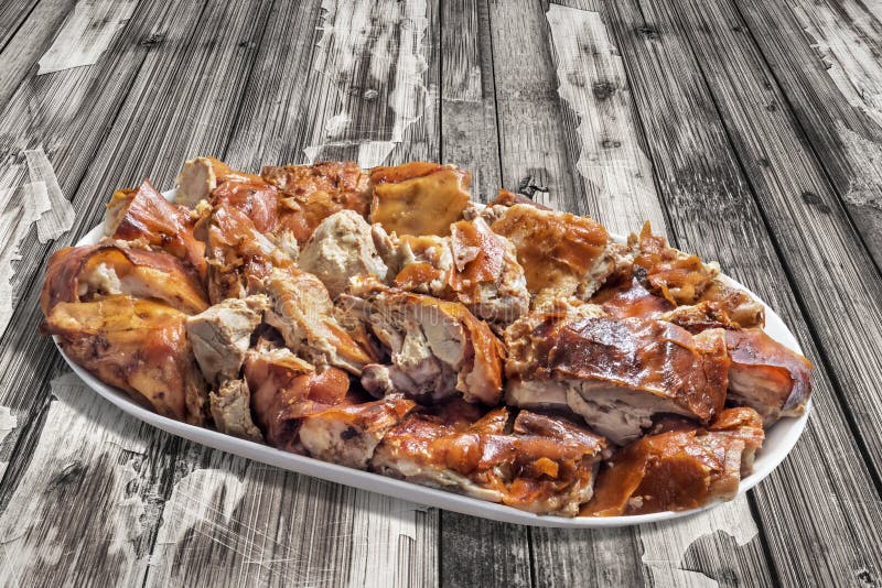 Plateful of Spit Roasted Pork Meat Slices on Old Weathered Cracked Flaky Wooden Picnic Table