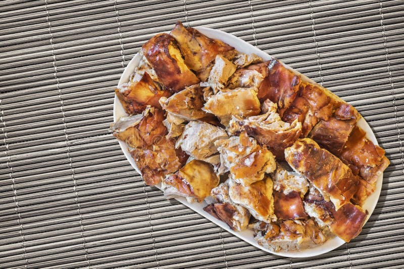 Plateful зажаренных в духовке вертелом кусков свинины установленных на поверхность Grunge циновки места соломы стоковое фото rf Plateful зажаренных в духовке вертелом кусков свинины установленных на поверхность Grunge циновки места соломы стоковое фото rf