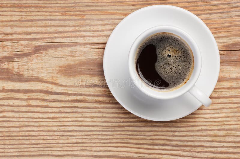 Platillo y taza de café blancos con espuma en la opinión superior del fondo de madera rústico de la tabla con el espacio para el fotos de archivo