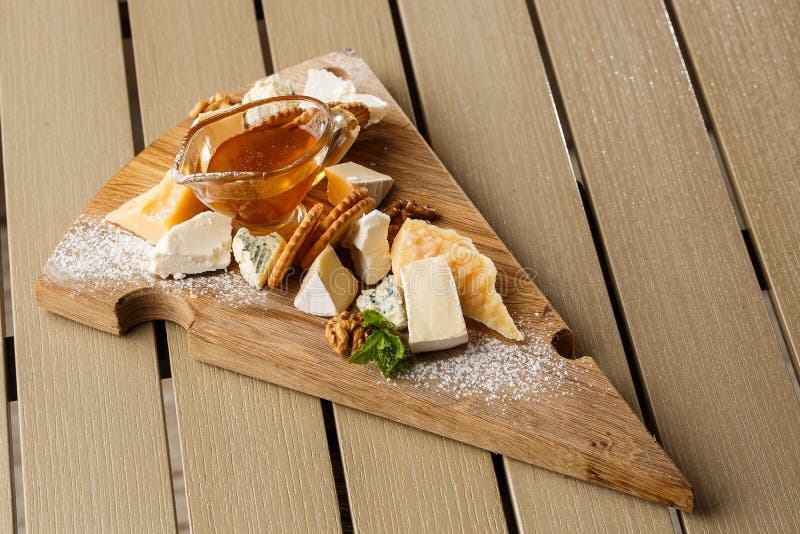 Plato del queso de la prueba en una placa de madera Comida para el vino y rom?ntico, charcuter?a del queso en una tabla r?stica d foto de archivo Plato del queso de la prueba en una placa de madera Comida para el vino y rom?ntico, charcuter?a del queso en una tabla r?stica d foto de archivo