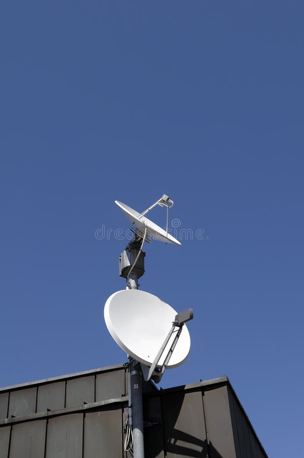 Platos basados en los satélites en tejado imagen de archivo libre de regalías Platos basados en los satélites en tejado imagen de archivo libre de regalías