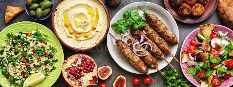 Plats arabes et du Moyen-Orient arrangés sur fond rustique sombre, frontière Hummus, taboulé, salade Fattoush, pita, brochettes d