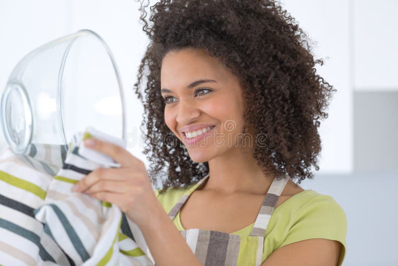 Plats de lavage de belle jeune femme au foyer avec l'éponge photographie stock Plats de lavage de belle jeune femme au foyer avec l'éponge photographie stock