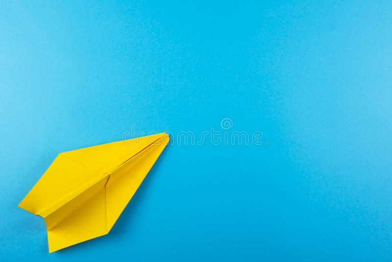Flat lay of color paper plane on blue color paper background. Business for innovative solutionor air travel concept. Flat lay of color paper plane on blue color paper background. Business for innovative solutionor air travel concept