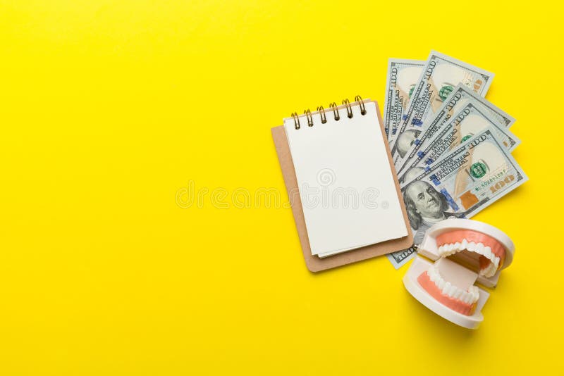 Platt lekkamera med bildande tandtypodontmodell och pengar med bärbar dator i färgad bordsöverblick arkivbild