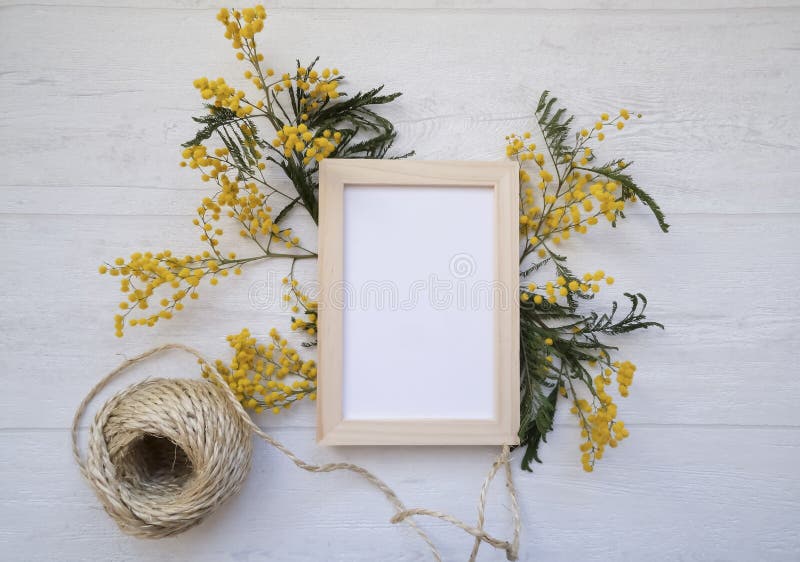 Platt, översiktsvy, vintage floral komposition, tom fotoram, jute-repeol och mimosa-blommor på den ljusgrå bakgrunden royaltyfria foton Platt, översiktsvy, vintage floral komposition, tom fotoram, jute-repeol och mimosa-blommor på den ljusgrå bakgrunden royaltyfria foton