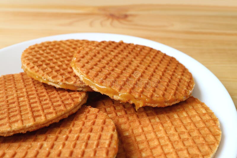 Plattan av Stroopwafel kakor, smakliga holländska traditionella sötsaker tjänade som på trätabellen royaltyfri bild Plattan av Stroopwafel kakor, smakliga holländska traditionella sötsaker tjänade som på trätabellen royaltyfri bild