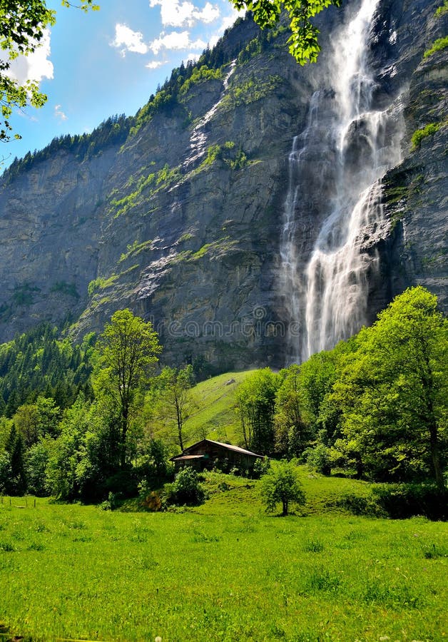 Plattelandshuisje onder een Zwitserse waterval stock foto Plattelandshuisje onder een Zwitserse waterval stock foto