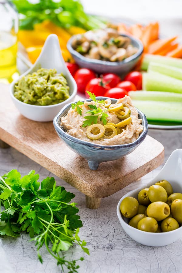 Platter of assorted fresh vegetables with avocado dip, hummus, marinated mushrooms