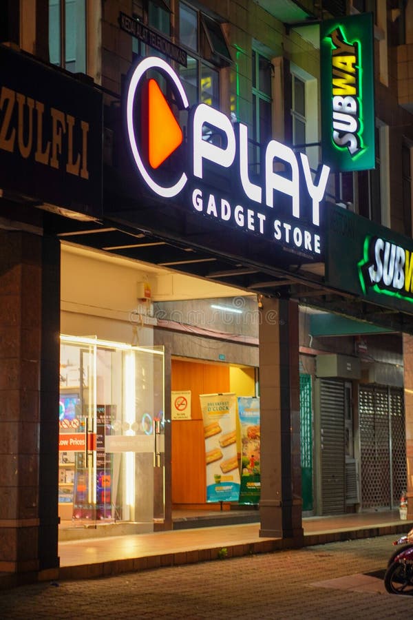 Play Gadget Store with Subway Signboard Glowing at Night Editorial