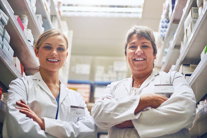 We play a key role in helping you to recover. Portrait of pharmacists standing in a isle with their arms crossed.