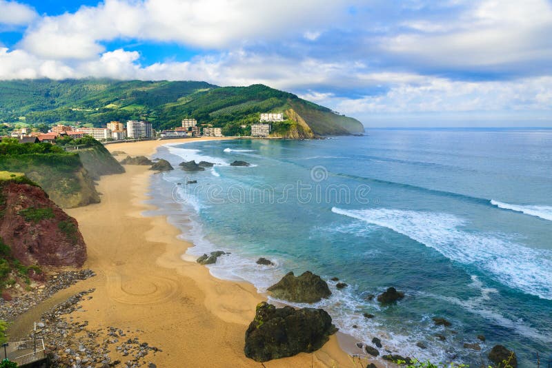 Playa arenosa hermosa con las buenas ondas para practicar surf en Bakio, país vasco, España imagenes de archivo Playa arenosa hermosa con las buenas ondas para practicar surf en Bakio, país vasco, España imagenes de archivo
