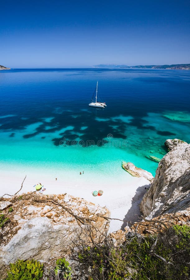 Playa de Fteri, Cephalonia Kefalonia, Grecia Yate blanco del catamarán en agua de mar azul clara Turistas en la playa arenosa cer fotos de archivo libres de regalías Playa de Fteri, Cephalonia Kefalonia, Grecia Yate blanco del catamarán en agua de mar azul clara Turistas en la playa arenosa cer fotos de archivo libres de regalías
