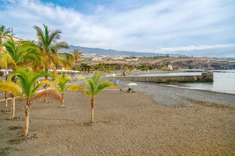 Playa de San Juan Tenerife的棕榈树和码头火山沙滩 免版税库存照片