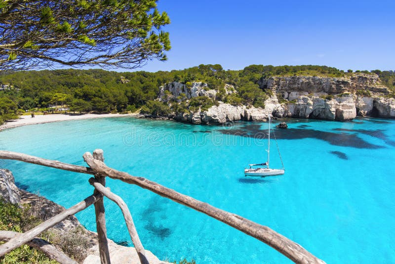Playa hermosa de Cala Macarella, isla de Menorca, EspaÃ±a Barco de navegaciÃ³n en una bahÃ­a DiversiÃ³n del verano, gozando de vi