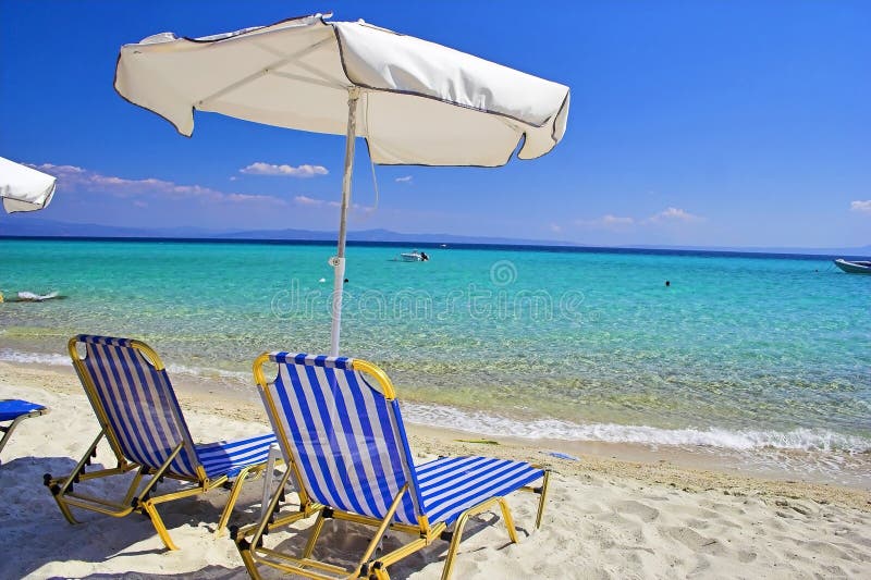 Two chairs and umbrella on desert beach. Two chairs and umbrella on desert beach