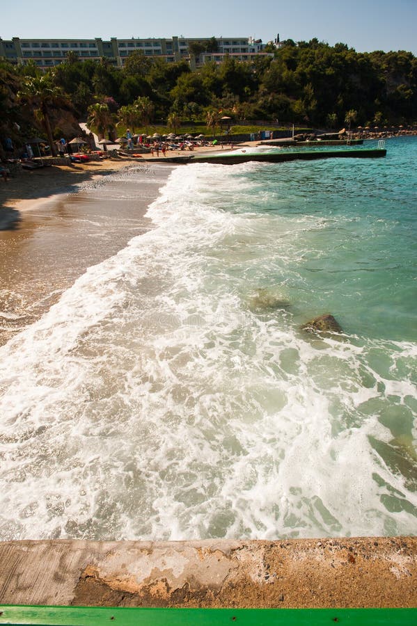Playa soleada con los turistas las ondas lavan la playa imagen de archivo libre de regalías Playa soleada con los turistas las ondas lavan la playa imagen de archivo libre de regalías