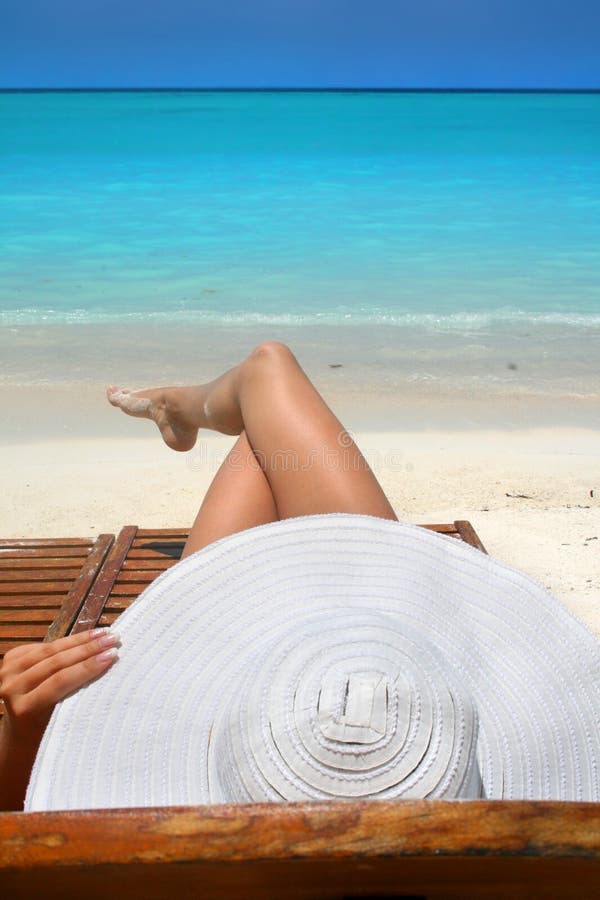 Woman with big white hat relaxing on the beach. Woman with big white hat relaxing on the beach