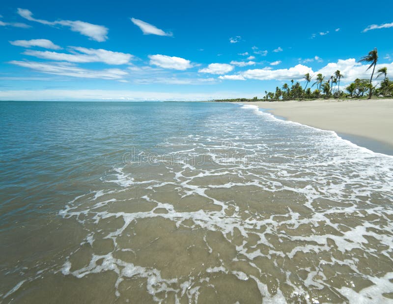 Playa tropical blanca amplia de Sandy con los smallwaves imagenes de archivo Playa tropical blanca amplia de Sandy con los smallwaves imagenes de archivo