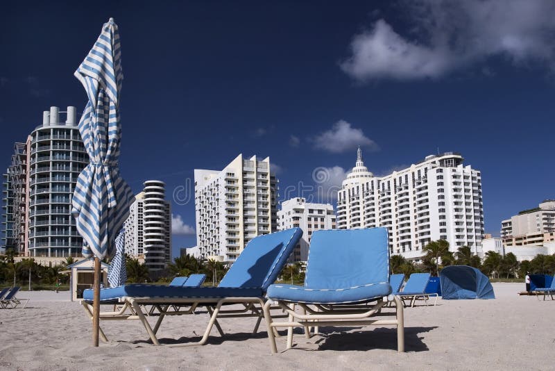 Chairs on the empty beach. South Beach (Miami) hotels in the background. Chairs on the empty beach. South Beach (Miami) hotels in the background