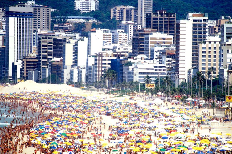 Crowd of people gathered on beach enjoying Carnival with Ipanema buildings in background. Crowd of people gathered on beach enjoying Carnival with Ipanema buildings in background