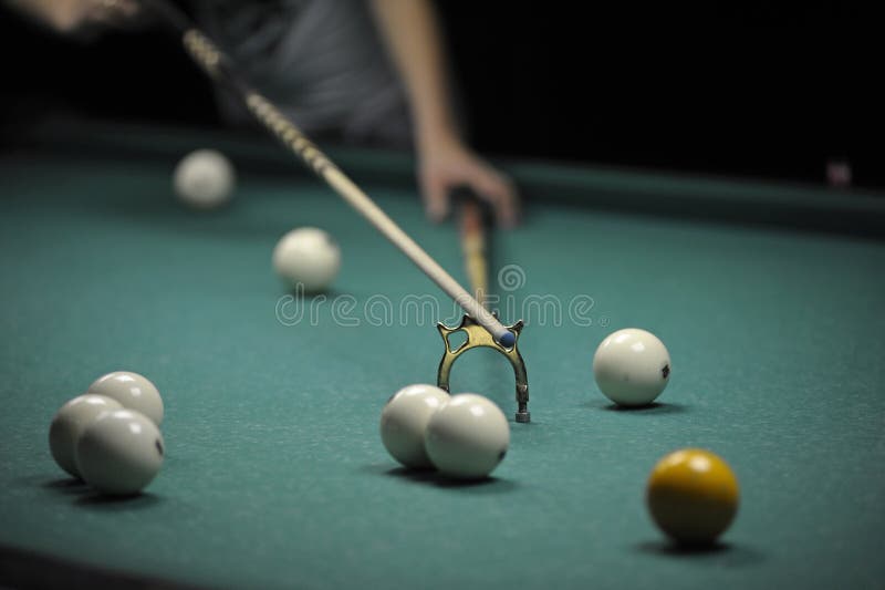Billiard Player Striking a Ball with Cue Stick Using the Rest Stock