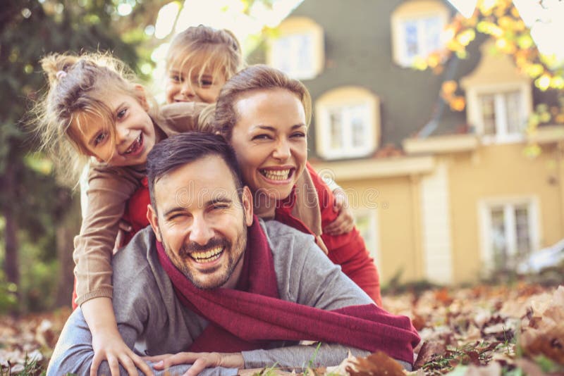 Happy family lying in autumn leaves. stock photo