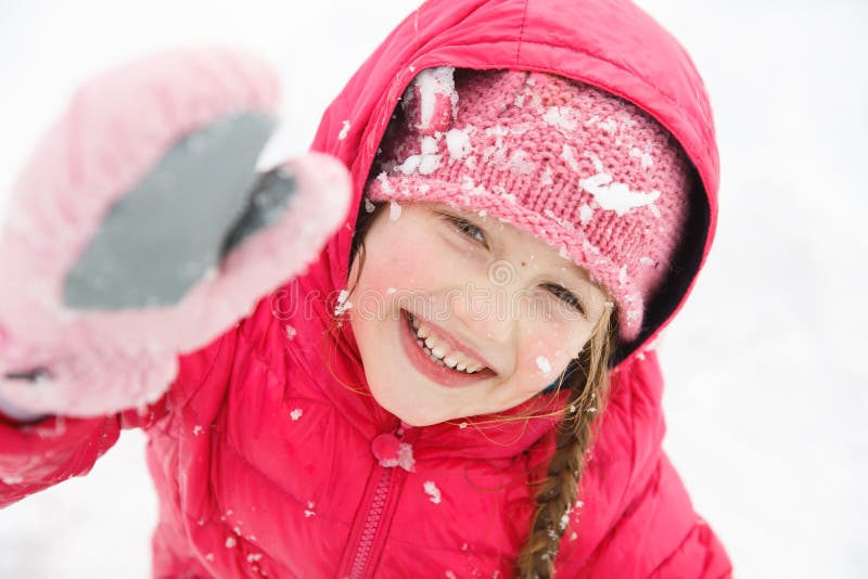 Playful girl with braids, enjoying winter and snow