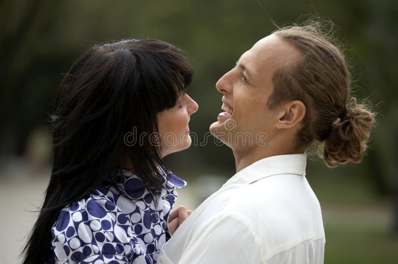 Playful love couple smiling in summer park