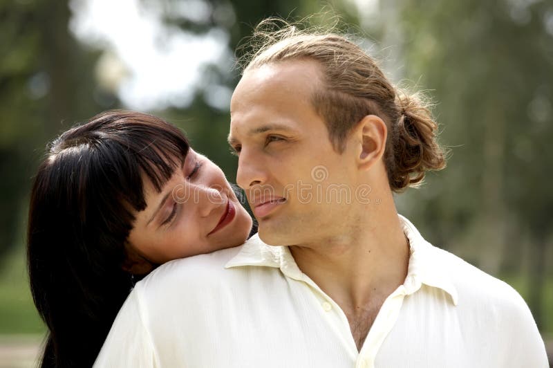 Playful love couple smiling in summer park