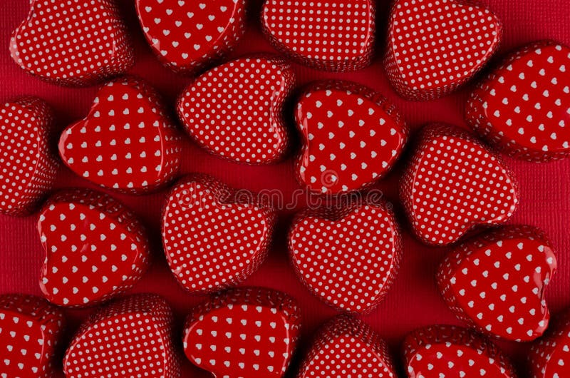 Playful red hearts on deep red paper. Valentine day background, pattern.