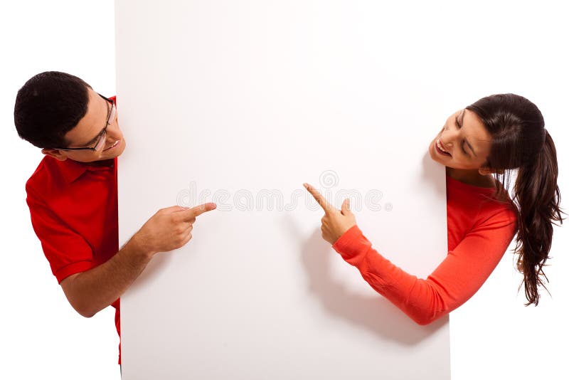 Playful young couple pointing the blank board