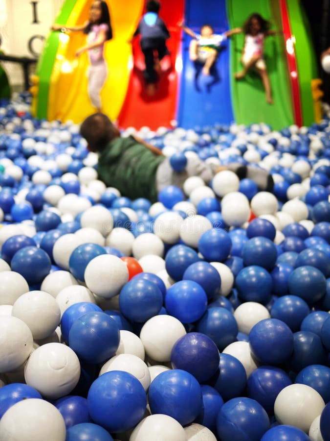 Carino bambini che giocano con la custodia di plastica colorata palle in un parco giochi al coperto.